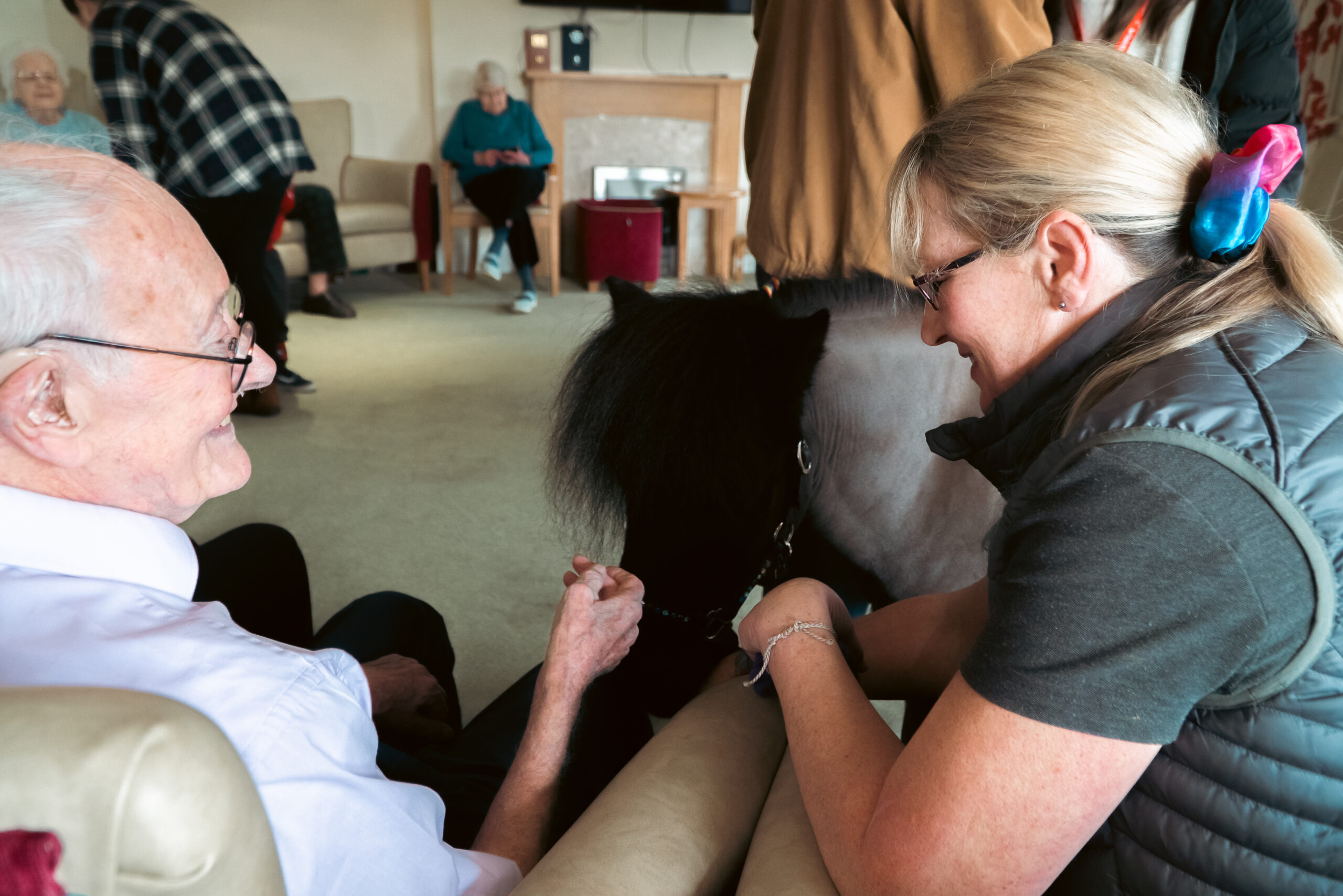 A Shetland pony visiting a resident at Cloverleaf Care Home, bringing joy and companionship.